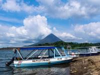 Boote am Ufer des Lago Arenal und Wolken am Vulkan Arenal